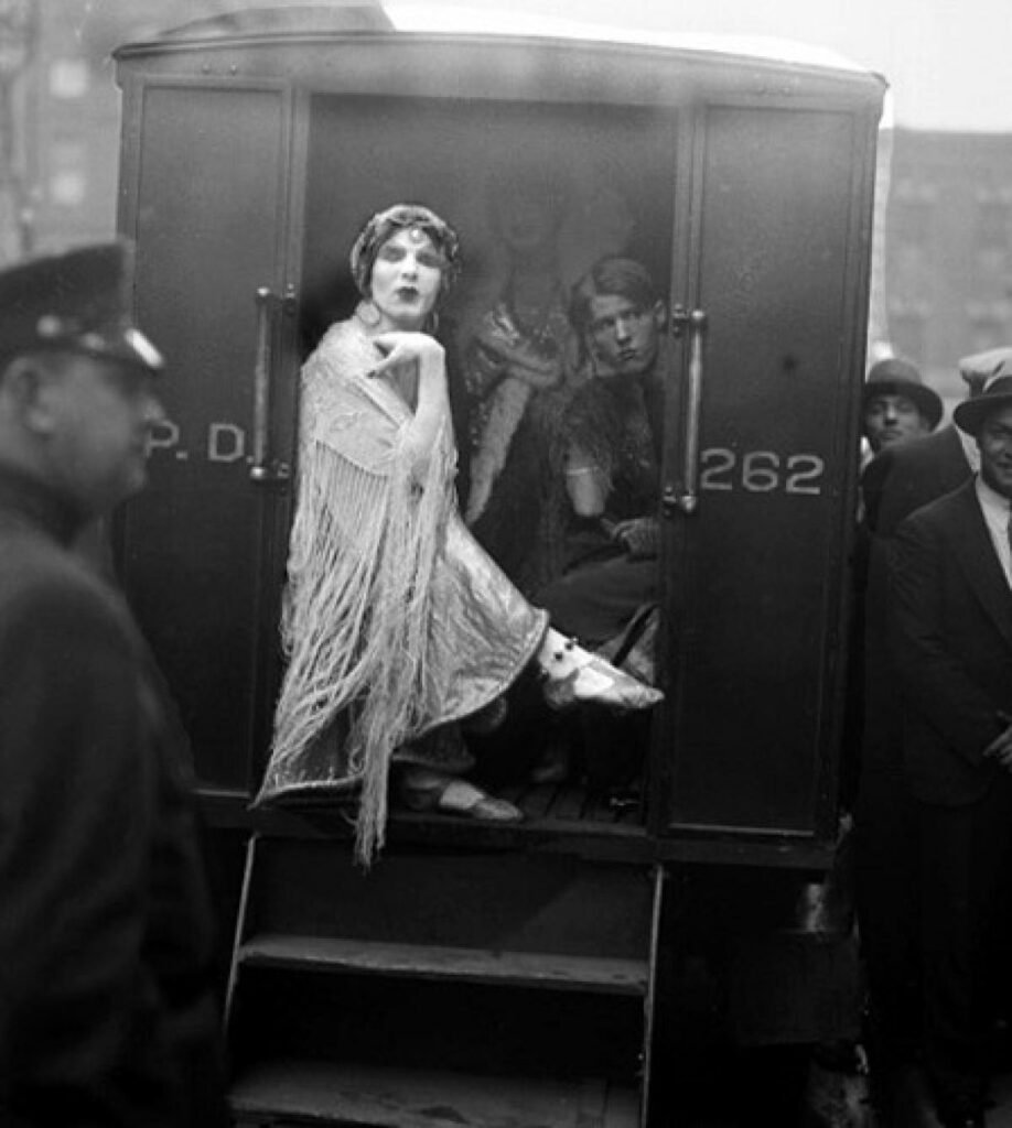 arrested cast and crew in the back of the police cart after being taken off stage