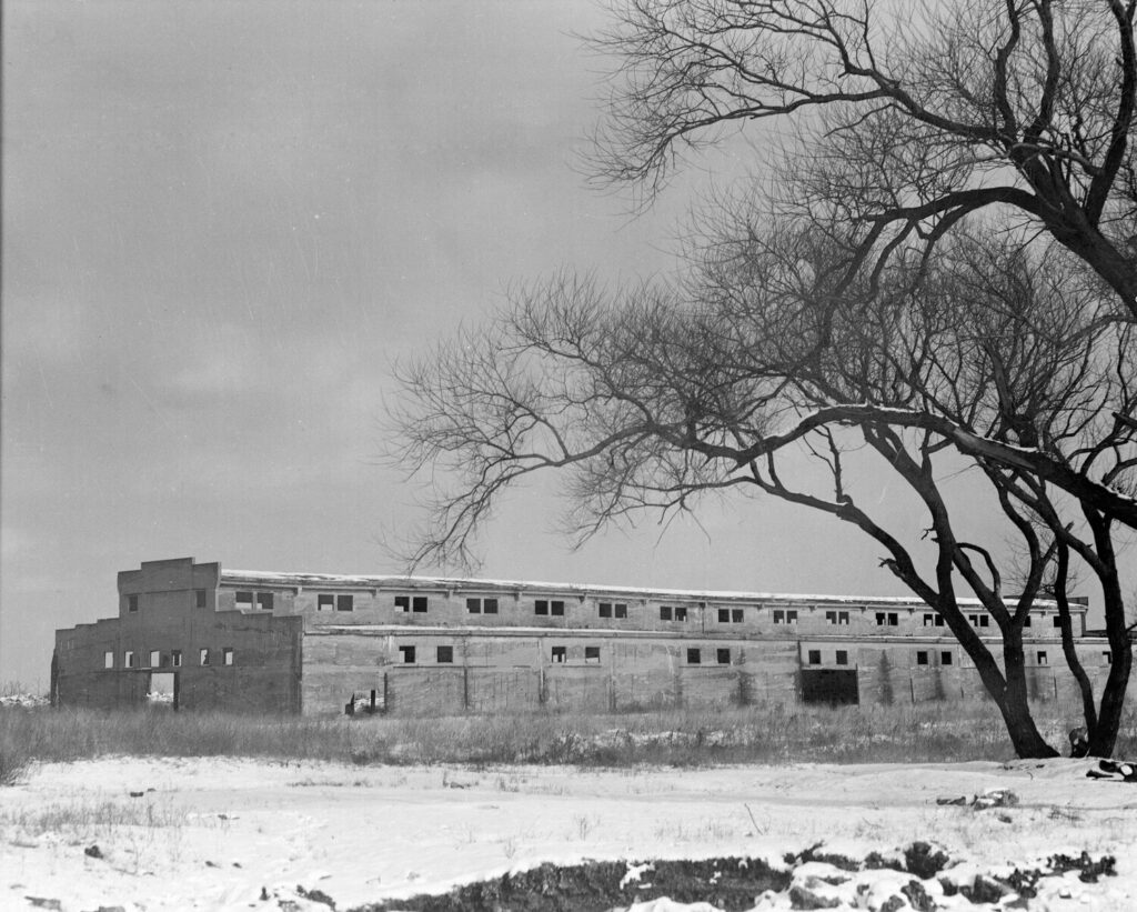 black and white photograph of a short, rectangular abandoned building