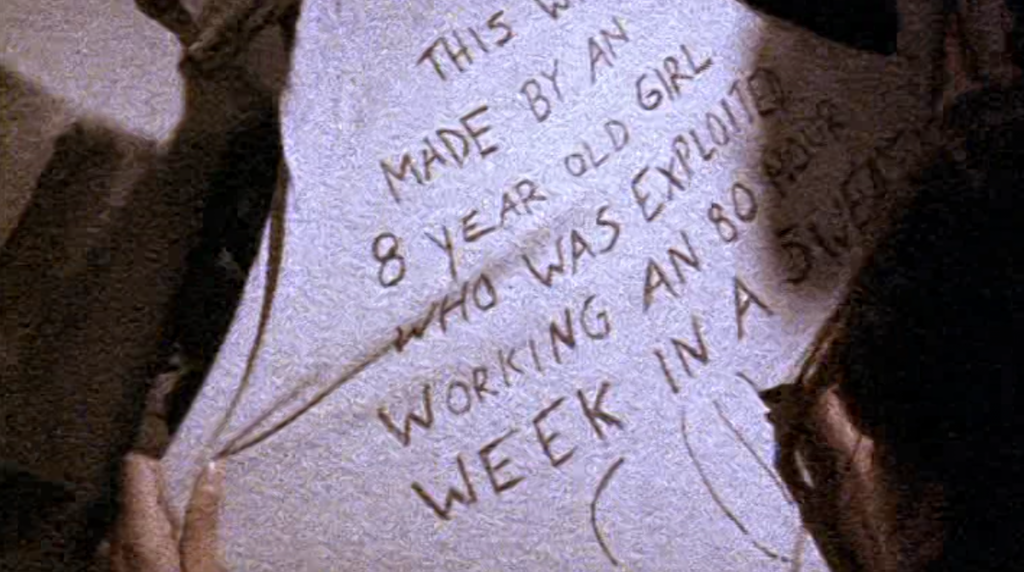 a shirt the C(I)A have written on in a shop: "This was made by an 8 year old girl who was exploited working an 80 hour week in a sweatshop. C(I)A"
