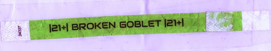 green wrist band, text: "[21+] Broken Goblet [21+]