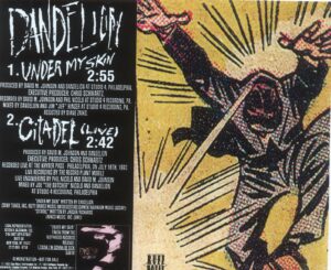 back of "Under My Skin" single: left side are credits; right side: a comic of a white man in suit jumping/falling, sending out or receiving rays of light